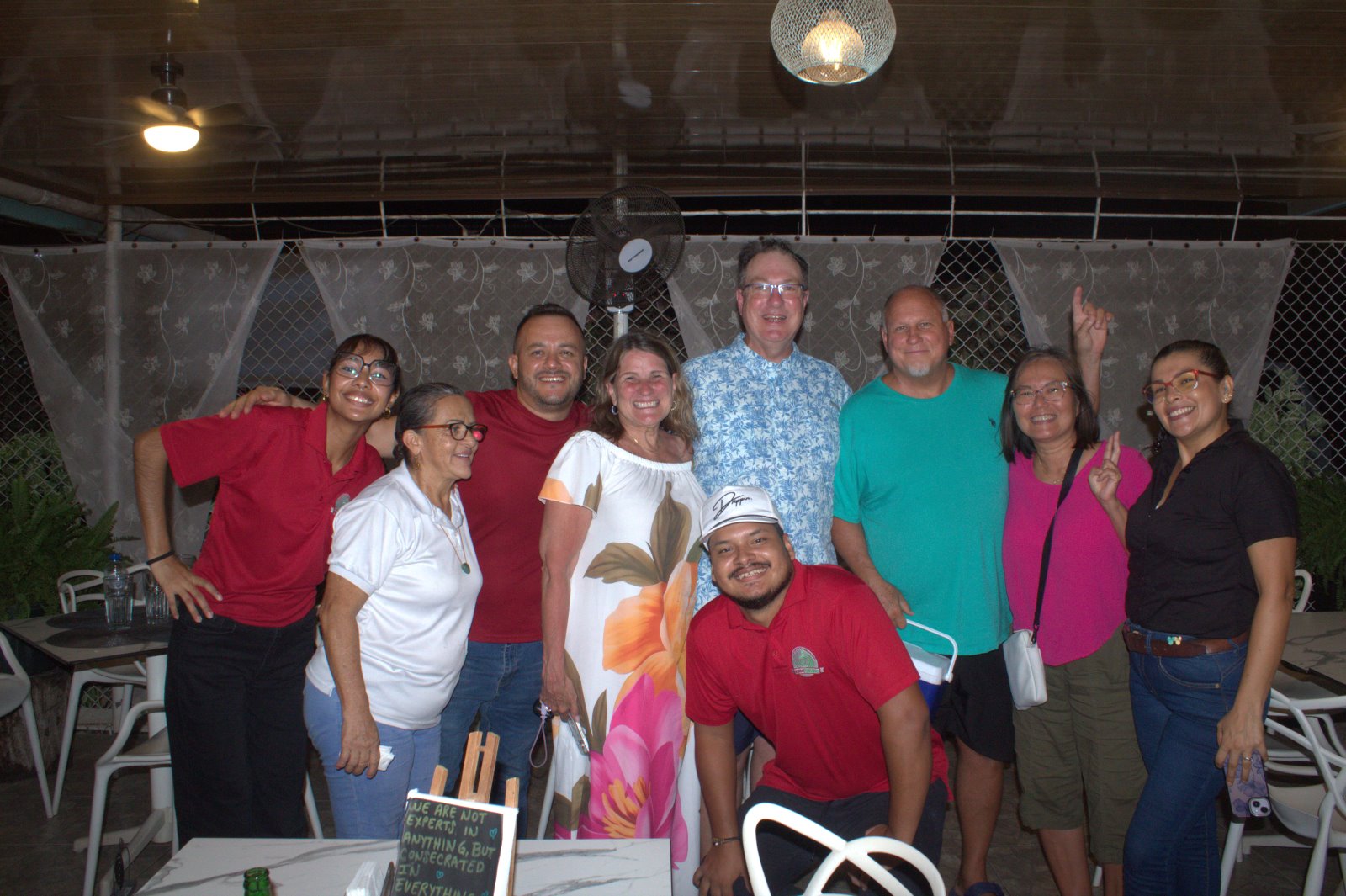 Clientes y equipo de Mambo Italiano posando juntos y sonriendo en la terraza